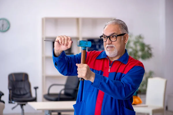 Oude mannelijke monteur aan het werk in de werkplaats — Stockfoto