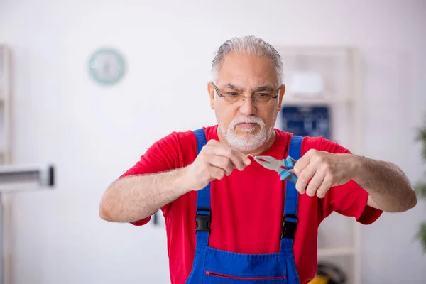 Oude mannelijke reparateur op de werkplaats — Stockfoto