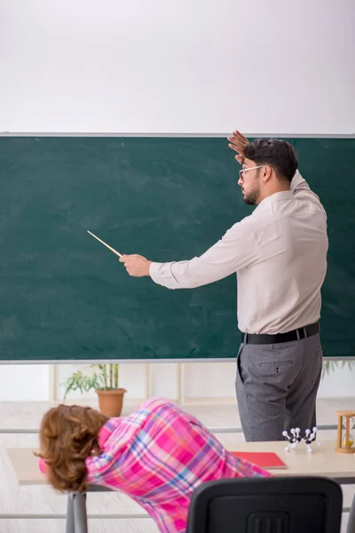 Jong man leraar en roodharige meisje in de klas — Stockfoto