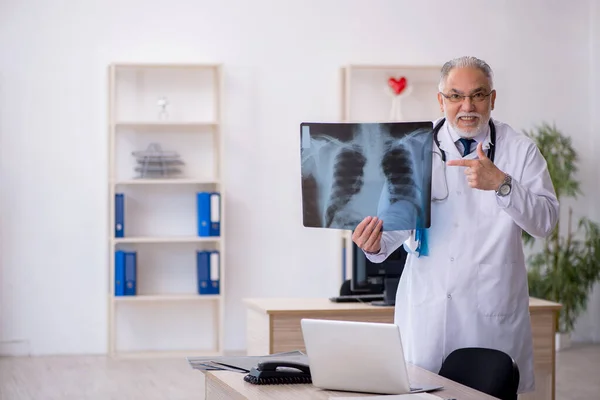 Klinikte çalışan yaşlı bir erkek radyolog. — Stok fotoğraf