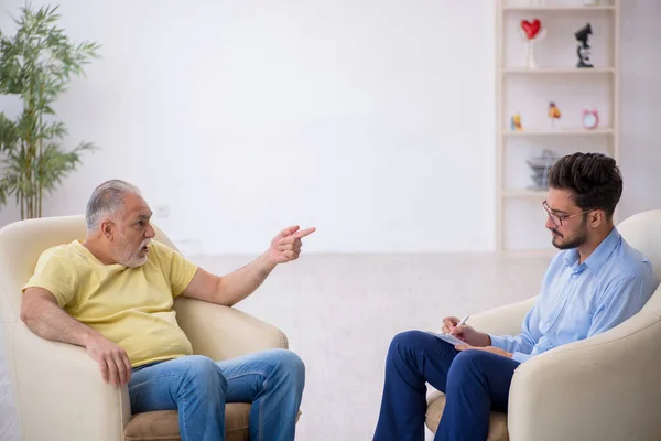 Alter Mann besucht jungen männlichen Psychotherapeuten — Stockfoto