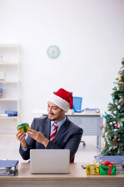 Young male employee celebrating Christmas at workplace — Stock Photo, Image