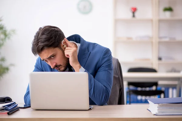 Döva manliga arbetstagare som använder hörapparat på arbetsplatsen — Stockfoto