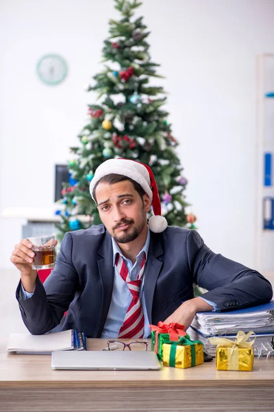 Jonge mannelijke werknemer viert Kerstmis op het werk — Stockfoto