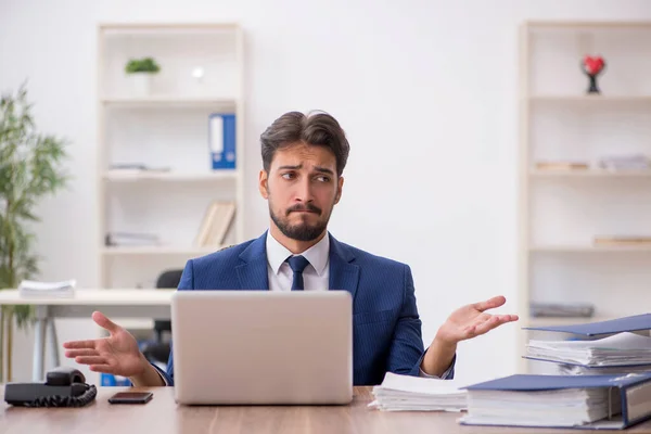 Ung manlig anställd missnöjd med överdrivet arbete på kontoret — Stockfoto