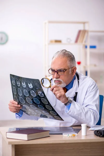 Gammal manlig röntgenläkare som arbetar på kliniken — Stockfoto