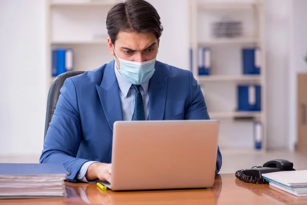 Młody pracownik biznesowy pracujący w biurze podczas pandemii — Zdjęcie stockowe