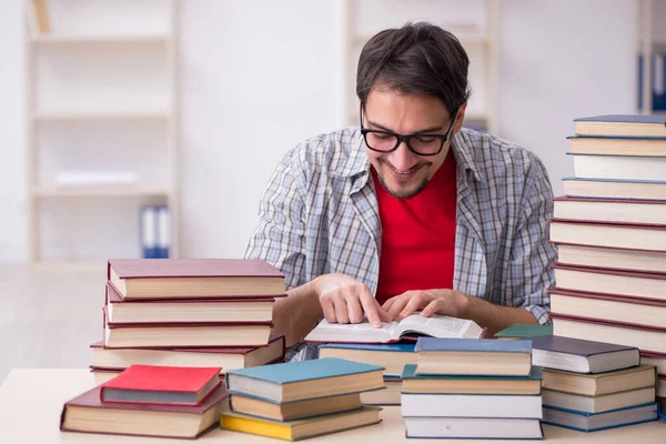 Junge männliche Schüler und zu viele Bücher im Klassenzimmer — Stockfoto