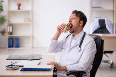 Klinikte çalışan genç erkek doktor.