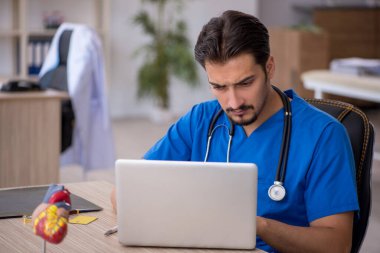 Klinikte çalışan genç erkek doktor.