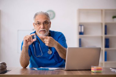 Klinikte çalışan yaşlı erkek doktor.