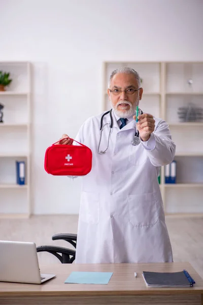Old male doctor holding first aid bag — Stock Photo, Image
