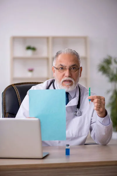 Klinikte çalışan yaşlı erkek doktor. — Stok fotoğraf