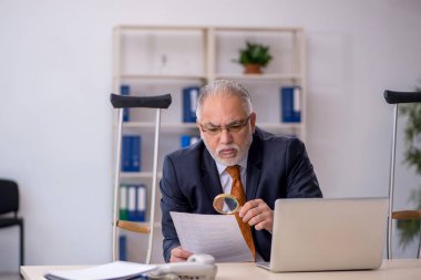 İş yerinde geçirdiği kazadan sonra yaşlı bir erkek işçi.