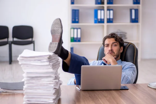 Junge männliche Mitarbeiter und zu viel Arbeit im Büro — Stockfoto