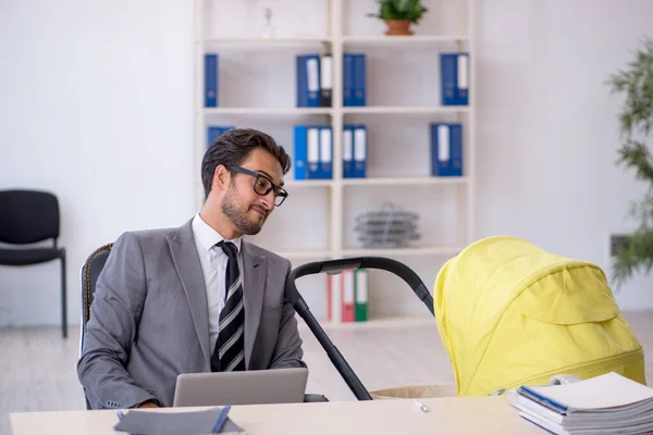 Jeune employé masculin s'occupant d'un nouveau-né sur le lieu de travail — Photo