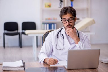 Klinikte çalışan genç erkek doktor.