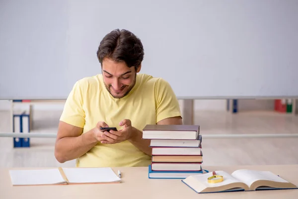 Joven estudiante masculino preparándose para los exámenes en el aula —  Fotos de Stock