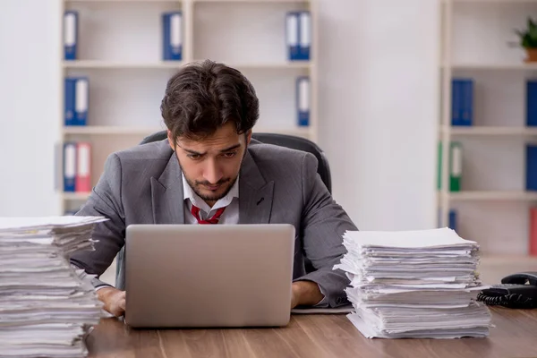 Jovem funcionário masculino infeliz com excesso de trabalho no escritório — Fotografia de Stock