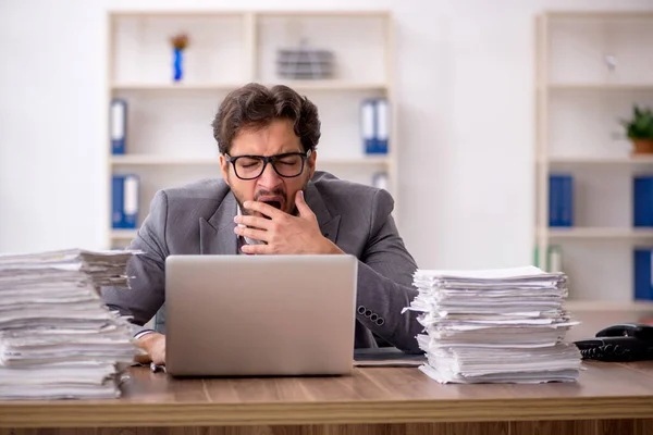 Jovem funcionário masculino infeliz com excesso de trabalho no escritório — Fotografia de Stock