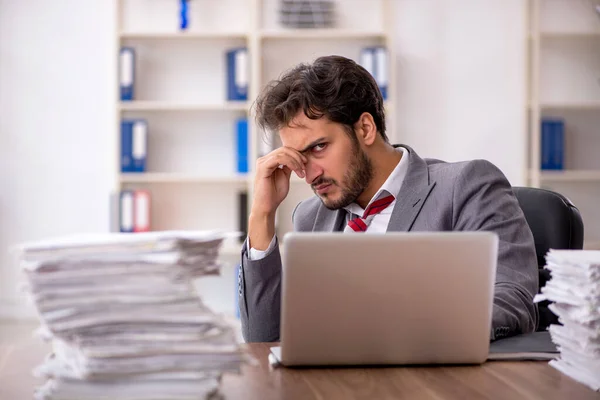 Joven empleado masculino descontento con el trabajo excesivo en la oficina — Foto de Stock