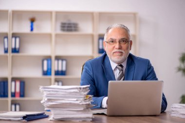 Ofiste çalışan yaşlı bir erkek.