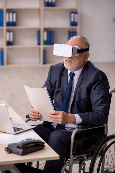 Viejo pierna lesionado empleado masculino usando gafas virtuales en workpla — Foto de Stock