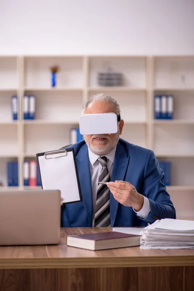 Åldrad man anställd bär virtuella glasögon på kontoret — Stockfoto