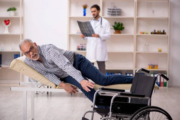 Velho homem ferido visitando jovem médico radiologista — Fotografia de Stock