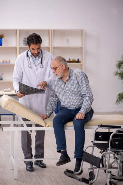 Viejo hombre herido visitando joven médico radiólogo — Foto de Stock