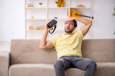 Evde sanal gözlük takan genç bir adam.