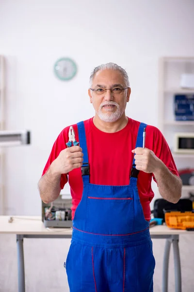 Oude mannelijke reparateur op de werkplaats — Stockfoto