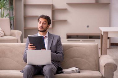 Genç erkek çalışan salgın sırasında evden çalışıyor.