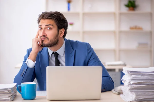 Junge männliche Mitarbeiter und zu viel Arbeit im Büro — Stockfoto