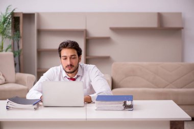 Genç erkek çalışan salgın sırasında evden çalışıyor.