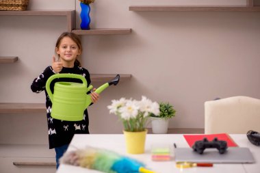 Küçük kız evde ev işi yapıyor.