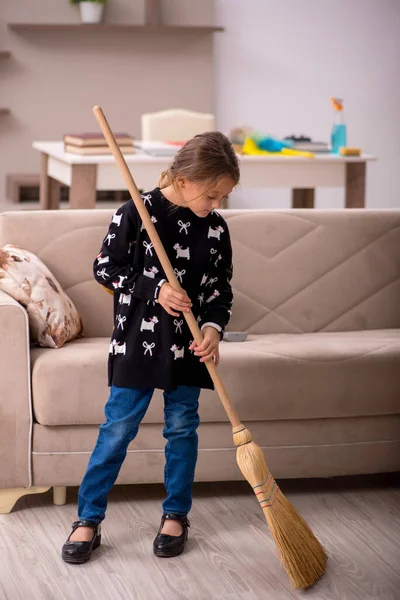 Küçük kız evde ev işi yapıyor.