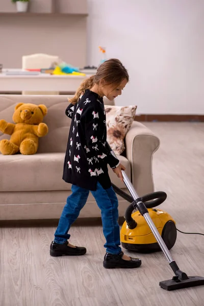 Küçük kız evde ev işi yapıyor.