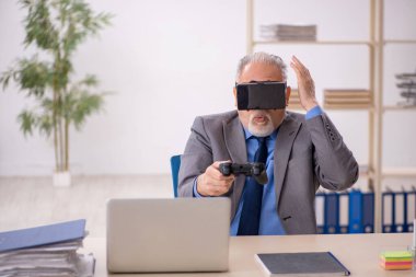 Eski erkek çalışanın iş yerinde sanal gözlüklerin keyfini çıkarması