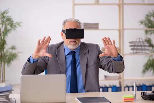 Старий чоловік працівник насолоджується віртуальними окулярами на робочому місці — стокове фото