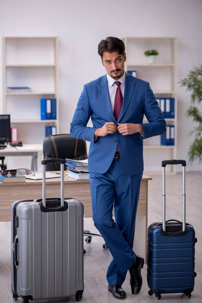 Jovem funcionário do sexo masculino se preparando para a viagem no local de trabalho — Fotografia de Stock