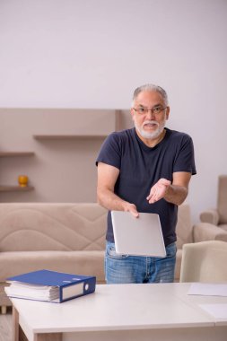 Salgın sırasında evde çalışan yaşlı bir erkek işçi.