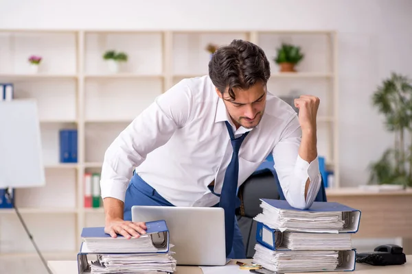 Jeune employé masculin et trop de travail au bureau — Photo