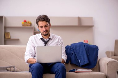 Genç erkek çalışan salgın sırasında evden çalışıyor.