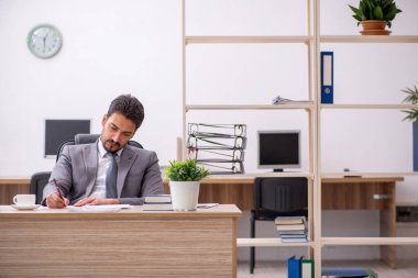 Ofiste çalışan genç bir erkek.