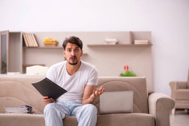 Genç erkek çalışan salgın sırasında evden çalışıyor.