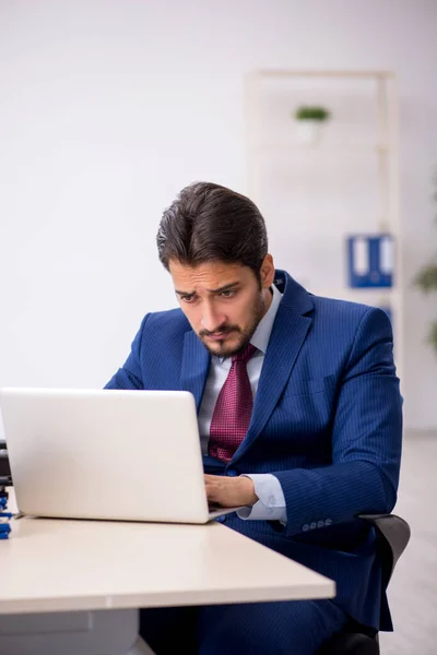 Joven empleado masculino que trabaja en el lugar de trabajo — Foto de Stock