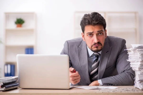 Jovem funcionário masculino infeliz com excesso de trabalho no escritório — Fotografia de Stock