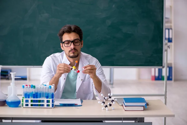 Jonge mannelijke chemicus voor schoolbord — Stockfoto