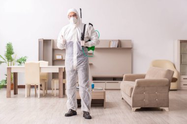 Genç erkek müteahhit evde haşere kontrolü yapıyor.